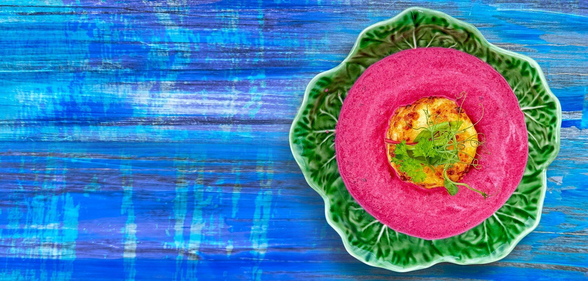 traditionelle pinke litauische Suppe auf blauem tisch serviert