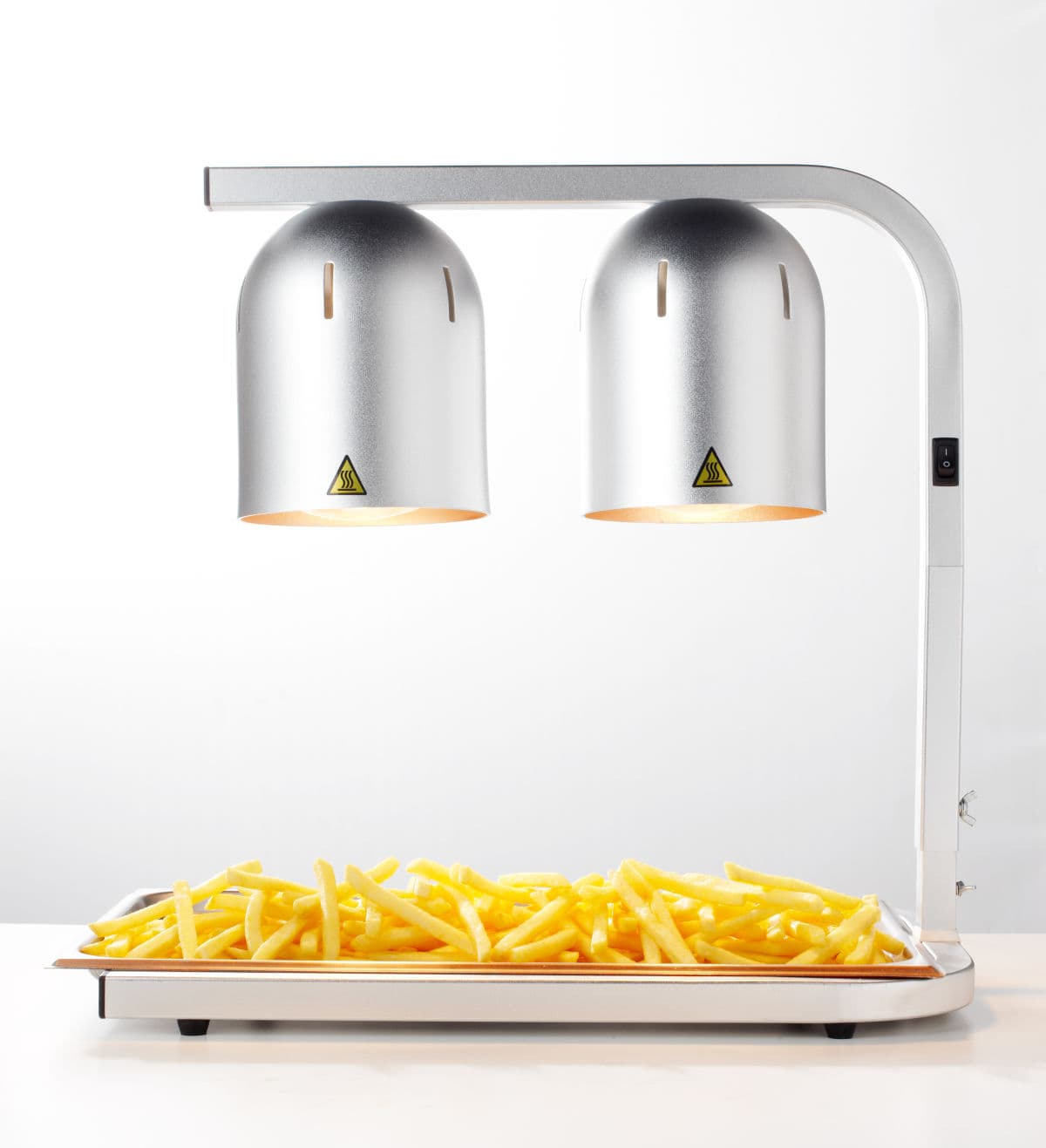 Warmgehaltene Gastro Pommes auf Tablett unter der Wärmelampe